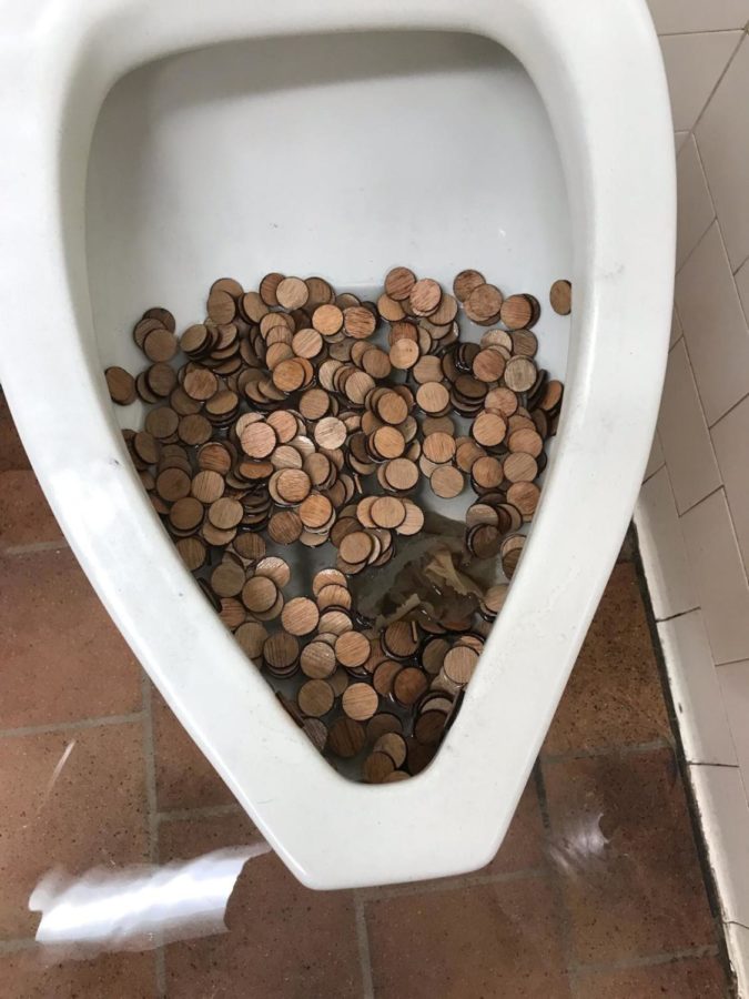 Wooden pennies fill the third floor boys bathroom urinal. The bathroom is closed until a district plumber can evaluate the damage.